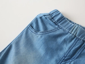 Close-up of elastic waistband and curved pockets on boys' denim summer shorts
