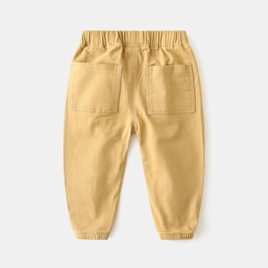 Detail view of ginger yellow cargo pants with elastic waistband and large back pockets
