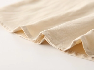Close-up of beige twill cotton fabric showing fine stitching and soft texture detail