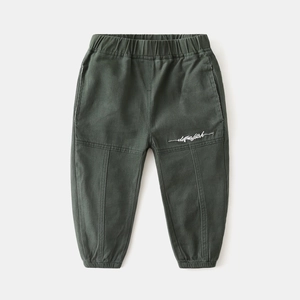 Detail of dark green boys cargo pants showing elastic waistband and white embroidery