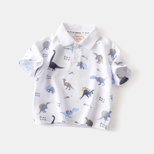 Detail of child polo shirt showing cotton fabric with colorful dinosaur patterns