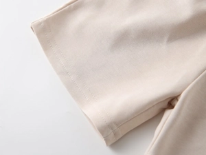 Detailed macro view of beige cotton knit fabric with reinforced double stitching seams