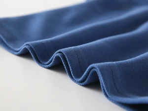 Close-up of navy blue pique knit fabric with durable double-needle stitching on the polo hem