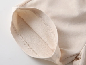 Detailed macro view of beige knit cotton fabric showing premium French Terry texture