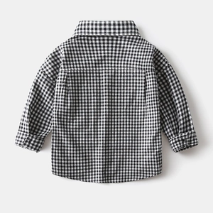 Detail view of boys' black and white checkered shirt with rounded hem and classic collar