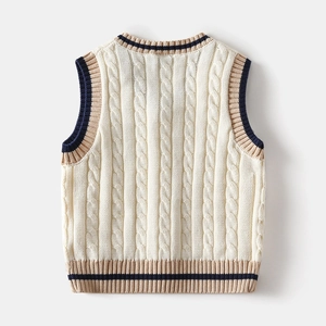 Detail of cable knit texture and navy striped ribbed edges on the back of a beige vest