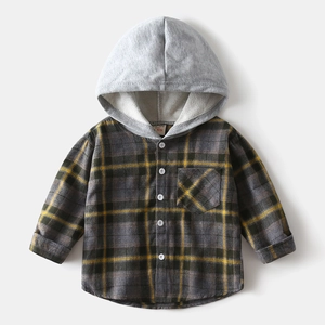 Détail d'une chemise à capuche pour garçon avec motifs à carreaux gris et jaunes
