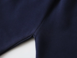 Detailed view of the durable crotch stitching on dark navy cotton knitted toddler pants