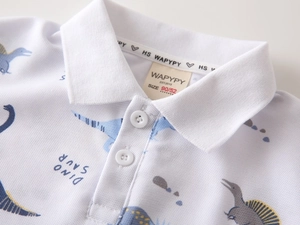 Close-up of boys' white polo shirt collar with blue dinosaur print and button details