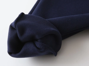 Macro shot of high-quality navy knit fabric with durable overlock stitching details