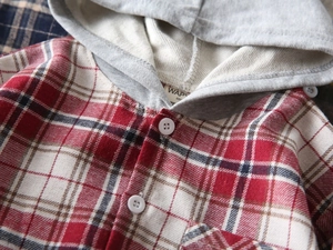 Détail d'une chemise à capuche à carreaux pour garçon avec boutons et texture