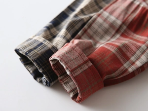Detail of checkered shirt cuffs with fine stitching and woven texture in blue and red
