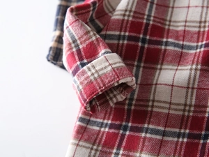 Détail du tissu en flanelle de coton à carreaux rouges et couture du poignet