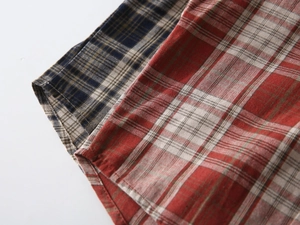 Detailed macro view of cotton plaid shirts featuring red and blue checkered fabric patterns