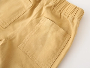Detail of boys' khaki cargo pants featuring elastic waistband and stitched back pockets