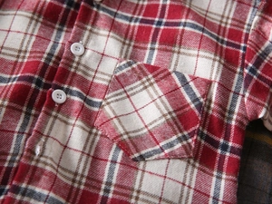 Détail d'une chemise à carreaux en flanelle rouge et bleu avec poche et boutons