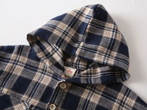 Detail view of navy plaid flannel hoodie with classic buttons and soft texture