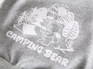 Detail of grey fleece sweatshirt featuring a white camping bear print and soft fabric texture