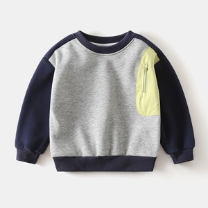 Détail d'un sweat pour garçon gris avec manches bleu marine et poche zippée vert fluo