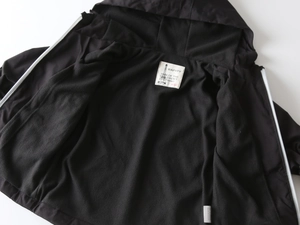 Detail of warm black fleece lining and branded size label on kid's hooded jacket