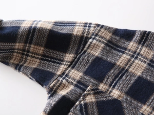 Macro shot of navy plaid flannel shirt fabric with soft brushed texture and neat seams