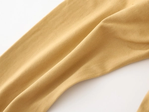 Detailed macro view of mustard yellow cotton twill fabric texture on boy's cargo pants