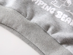 Macro detail of ribbed elastic hem and Jumping Bean print on gray fleece sweatshirt