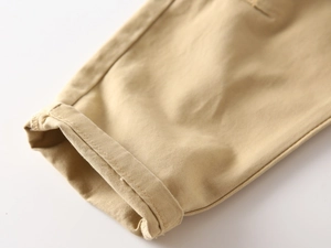 Close-up of the rolled hem and double stitching on khaki cotton twill trousers