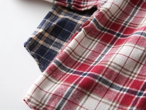 Gros plan sur la texture du tissu en coton à carreaux rouge et bleu marine pour garçons
