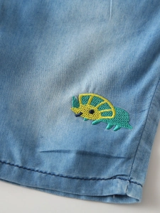 Kids light blue denim shorts featuring a detailed green cartoon triceratops embroidery