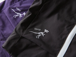 Detail of dinosaur skeleton print and ROAR text on kids fleece hooded jacket fabric