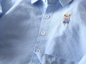 Gros plan d'une chemise en coton Oxford bleu clair pour garçons avec broderie ours