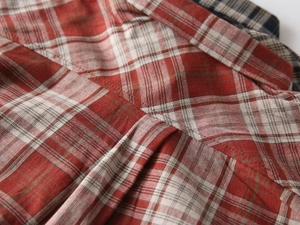 Detailed close-up of the red and beige plaid pattern fabric with precise double-stitching