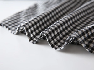 Macro detail of high-quality black and white gingham fabric showing texture and drape