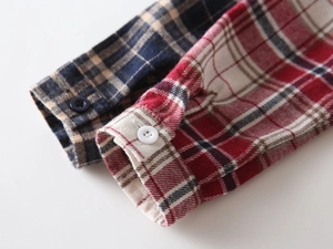 Gros plan des poignets de chemise à carreaux pour enfants avec boutons et texture fine