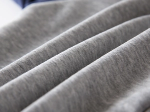 Close-up of premium heather grey fleece fabric showing soft knit texture and fiber detail
