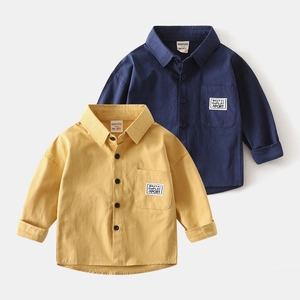 Detailed close-up of cotton boys' shirts featuring chest pockets and woven brand labels