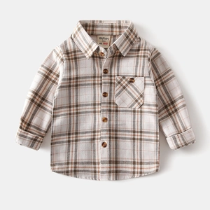 Detailed close-up of brown checkered cotton shirt featuring faux wood buttons and chest pocket