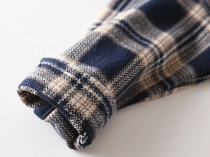 Detailed macro view of children's thick flannel plaid shirt cuff with herringbone texture