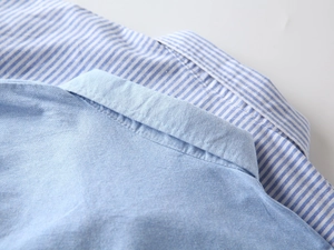 Détails de chemises Oxford pour garçons montrant les tissus bleu clair et rayés