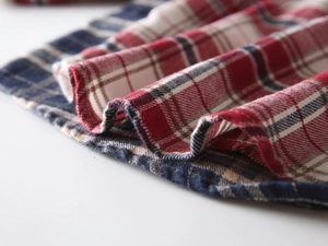 Gros plan sur le tissu en flanelle à carreaux rouge et bleu montrant la texture brossée
