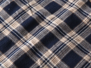 Macro shot of thick navy blue and grey plaid fabric with soft brushed texture