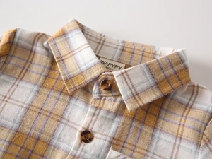 Close-up of yellow plaid flannel shirt showing brushed texture and tortoiseshell buttons