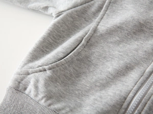 Detailansicht der Nähte und des Rippbündchens bei diesem grau melierten Jungen-Hoodie