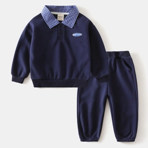 Detail of boys' navy blue tracksuit featuring plaid polo collar and GAME CHANGER patch
