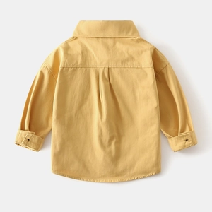 Detailed back view of boy's ginger yellow long-sleeved cotton shirt with pleated yoke