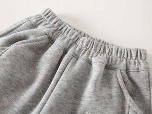 Macro detail of boys' heather grey fleece jogger showing elastic waist and stitching