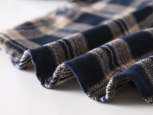 Macro shot of thick blue and beige plaid flannel fabric showing soft brushed texture