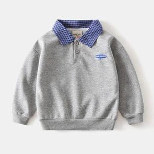 Detail of grey children polo sweatshirt with blue plaid collar and embroidered badge