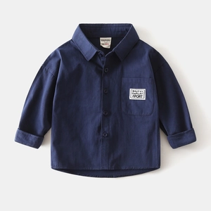 Close-up of deep blue boy's shirt with chest pocket and decorative sport label detail